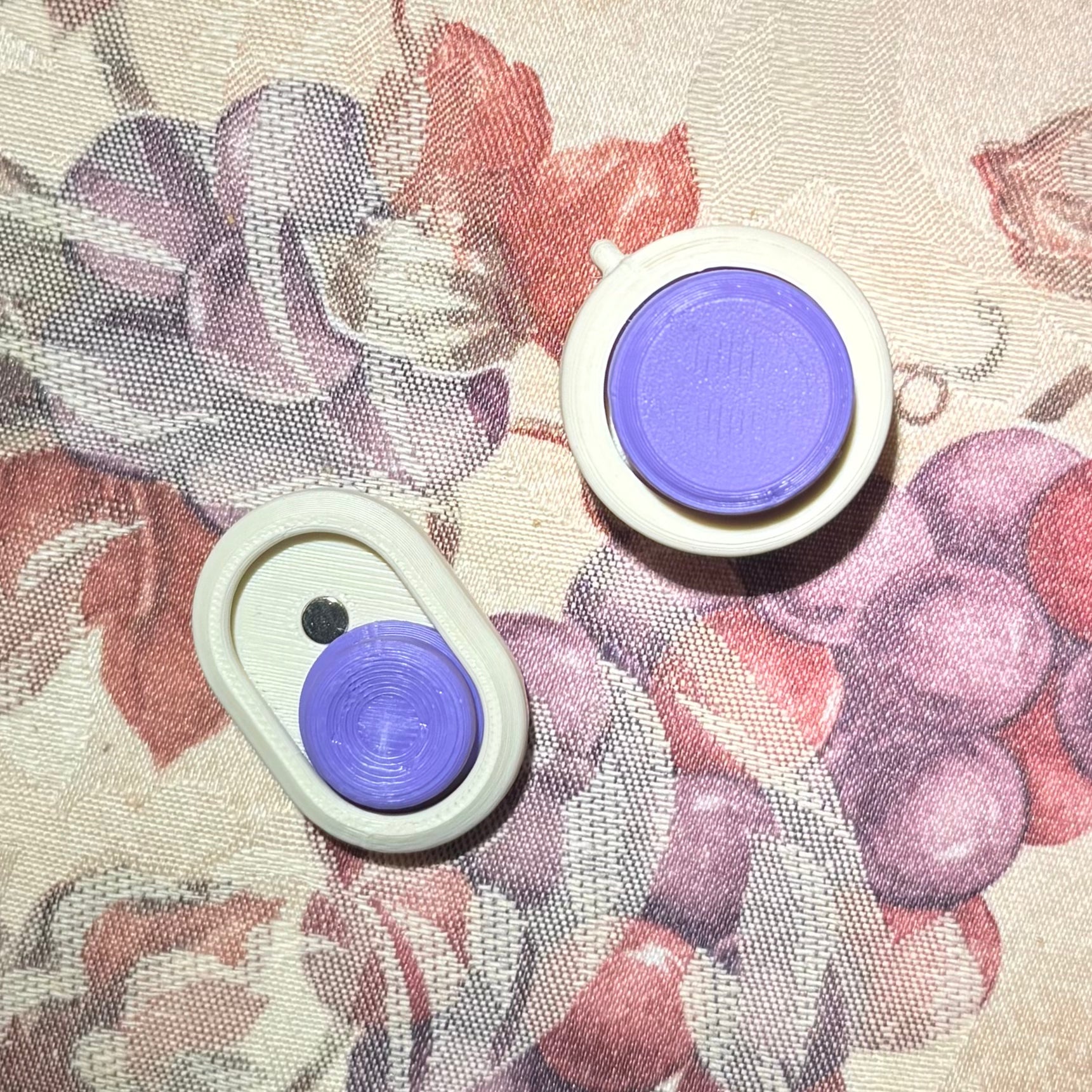 Snappy™ Hidden Gem Clicker in Snappy Click and Classic styles with purple buttons, designed for focus and creativity. Executive fidget toy on floral fabric.