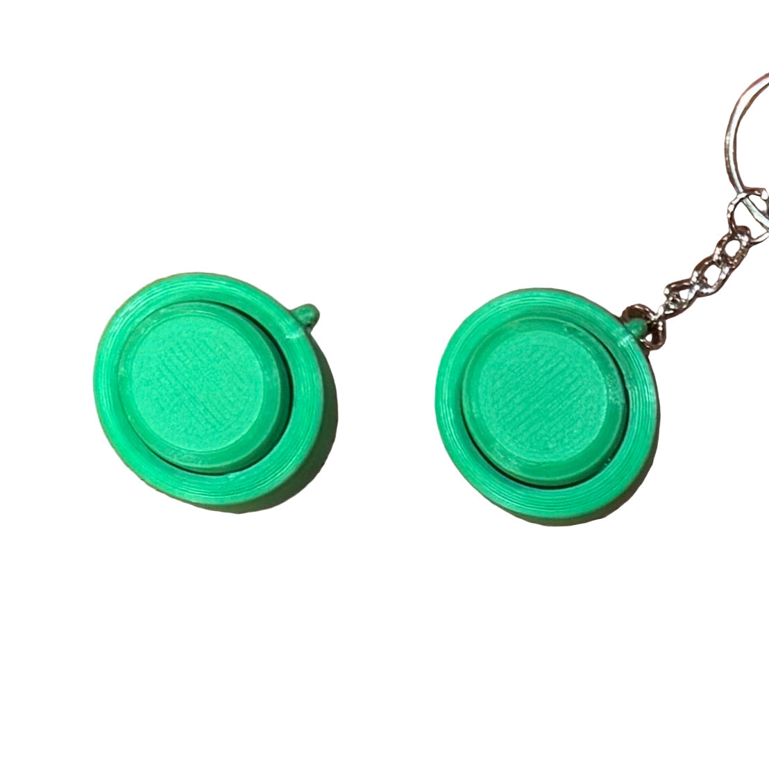 Green Snappy™ Click fidget toy shown with and without keychain. Compact mechanical keyboard-style stress reliever.