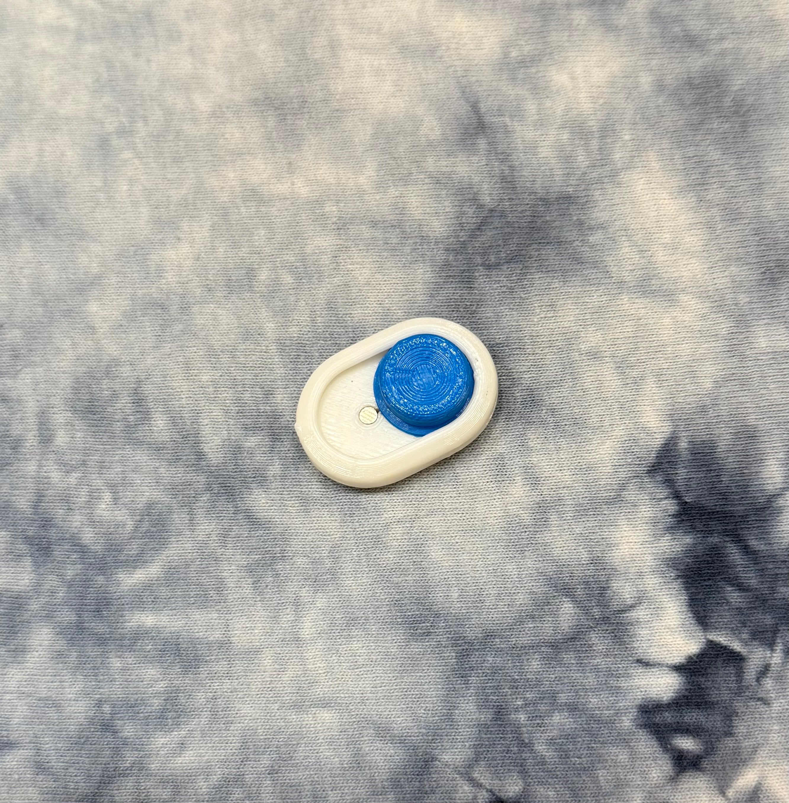 Compact Snow Cap Keychain in white with blue tactile button and keychain loop, ideal for portable executive toy use.